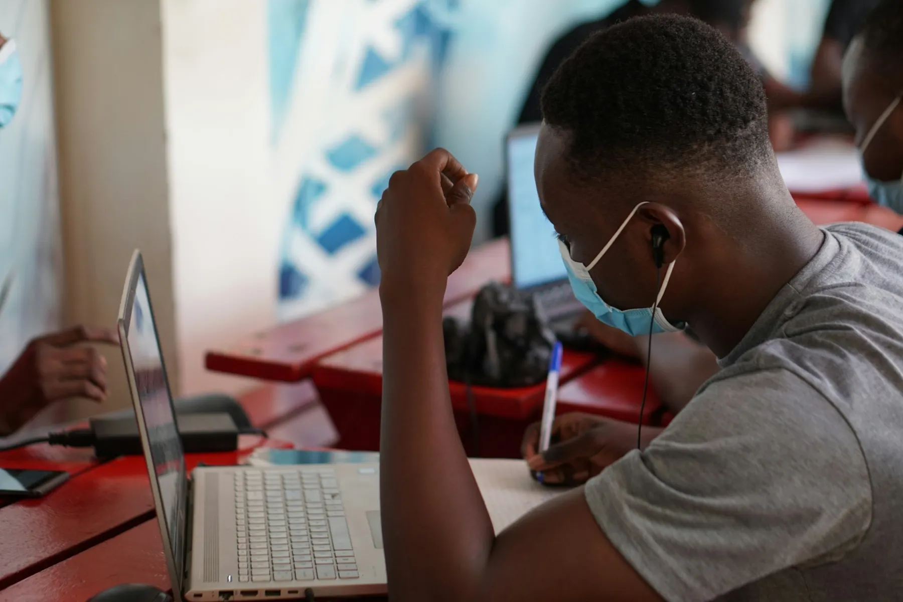 A student studying with a laptop and notes